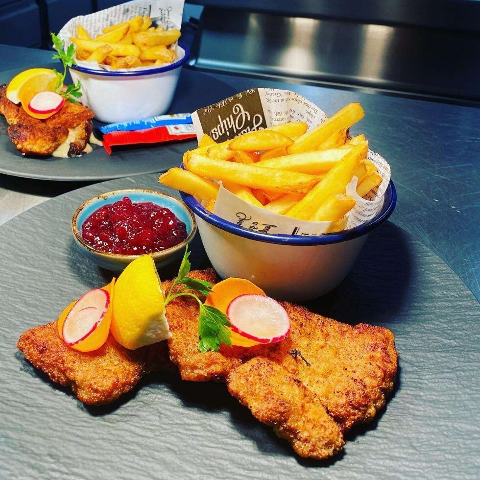 Paniertes Schnitzel mit Pommes und Preiselbeeren